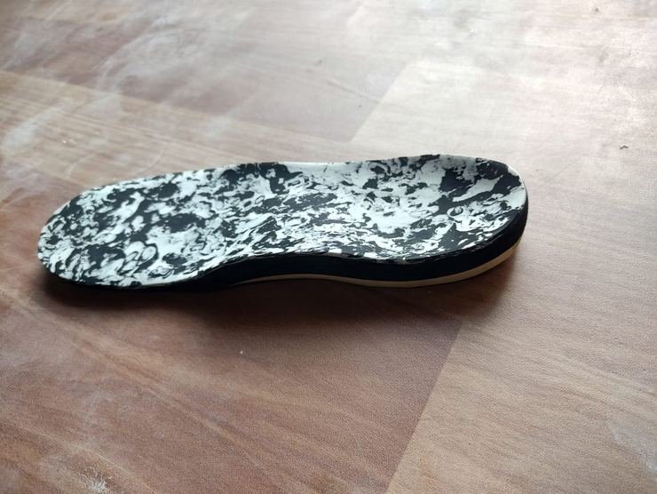 Custom insole showing moulded arch contour and heel cup