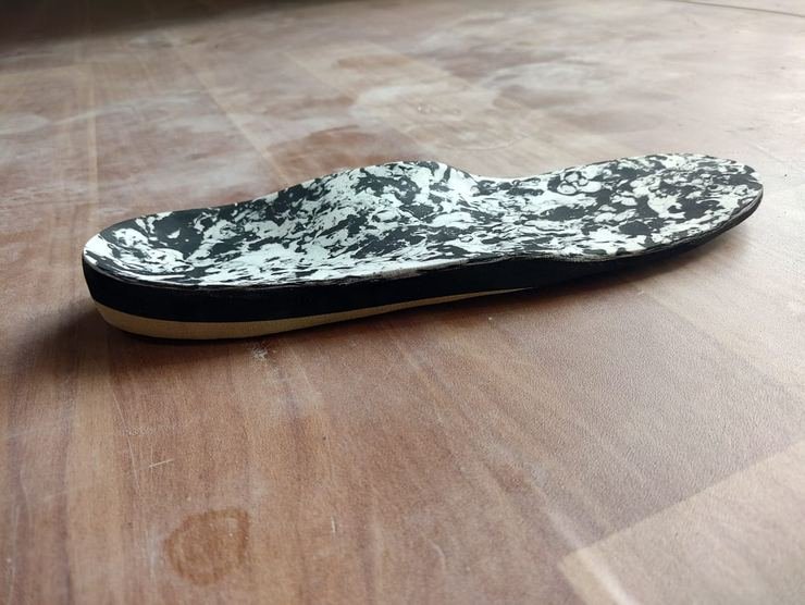 Custom orthotic insole side profile showing layer construction