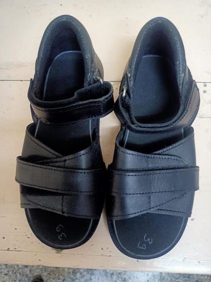 Pair of black orthopaedic sandals with cross-over straps