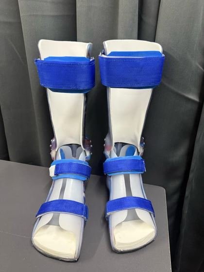 Solid ankle AFO pair in white thermoplastic with blue strapping