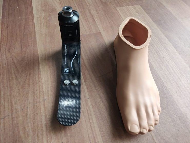 Ossur Flex-Foot Assure carbon fibre foot beside its cosmetic foot shell