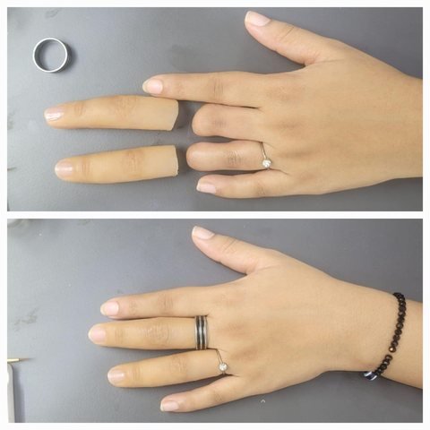 A two-digit silicone finger prosthesis with natural nails resting on a container beside a plain background